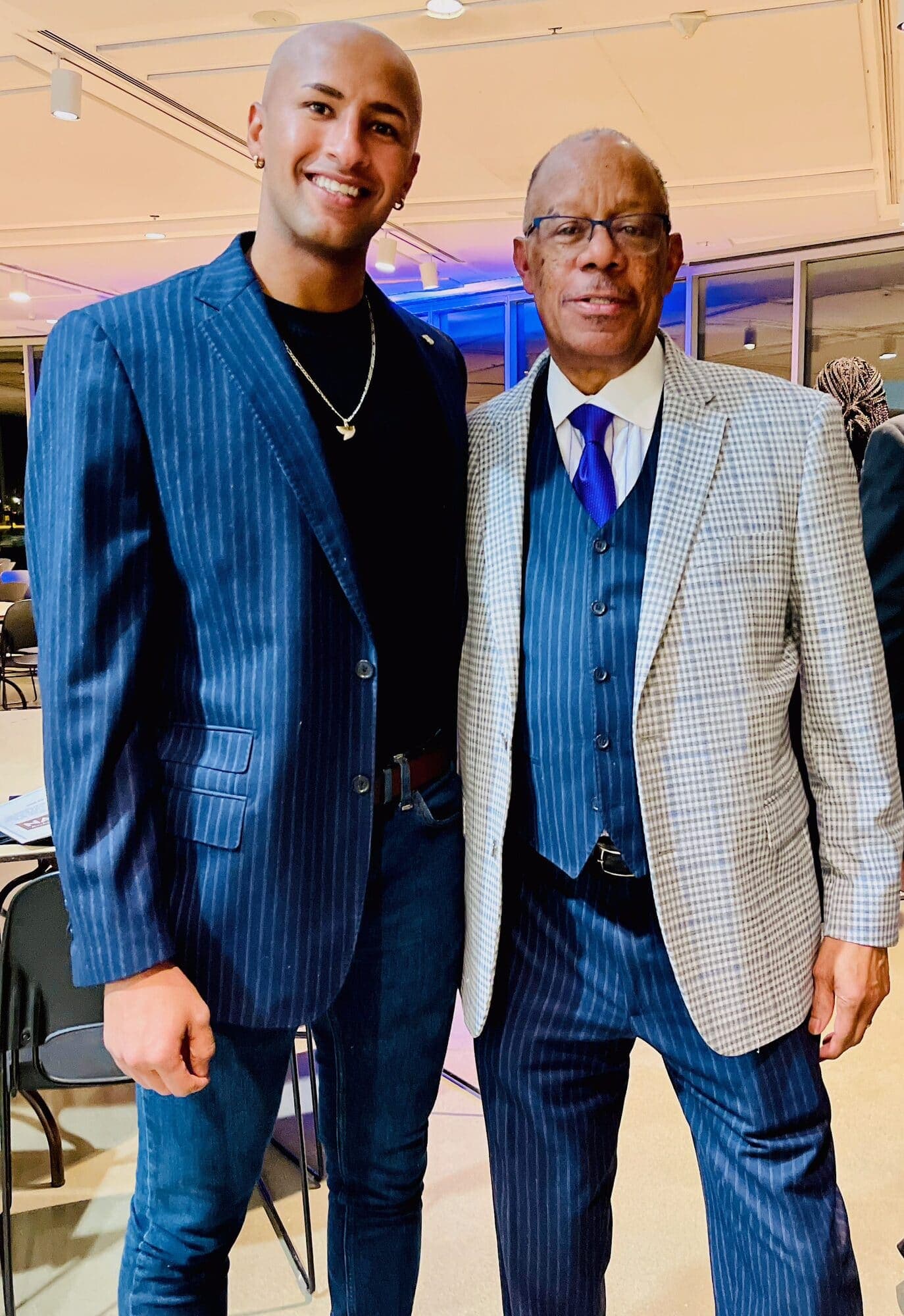Axe Ahmed with a Rochester community elder at an evening event, both in suits
