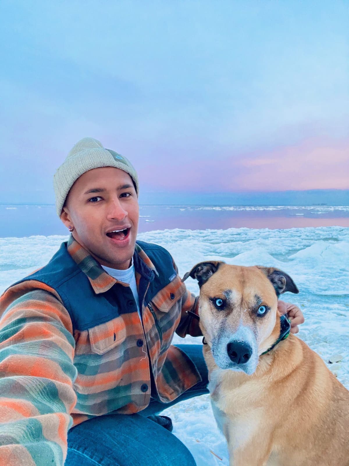 Axe Ahmed and his dog on a frozen lake at sunset
