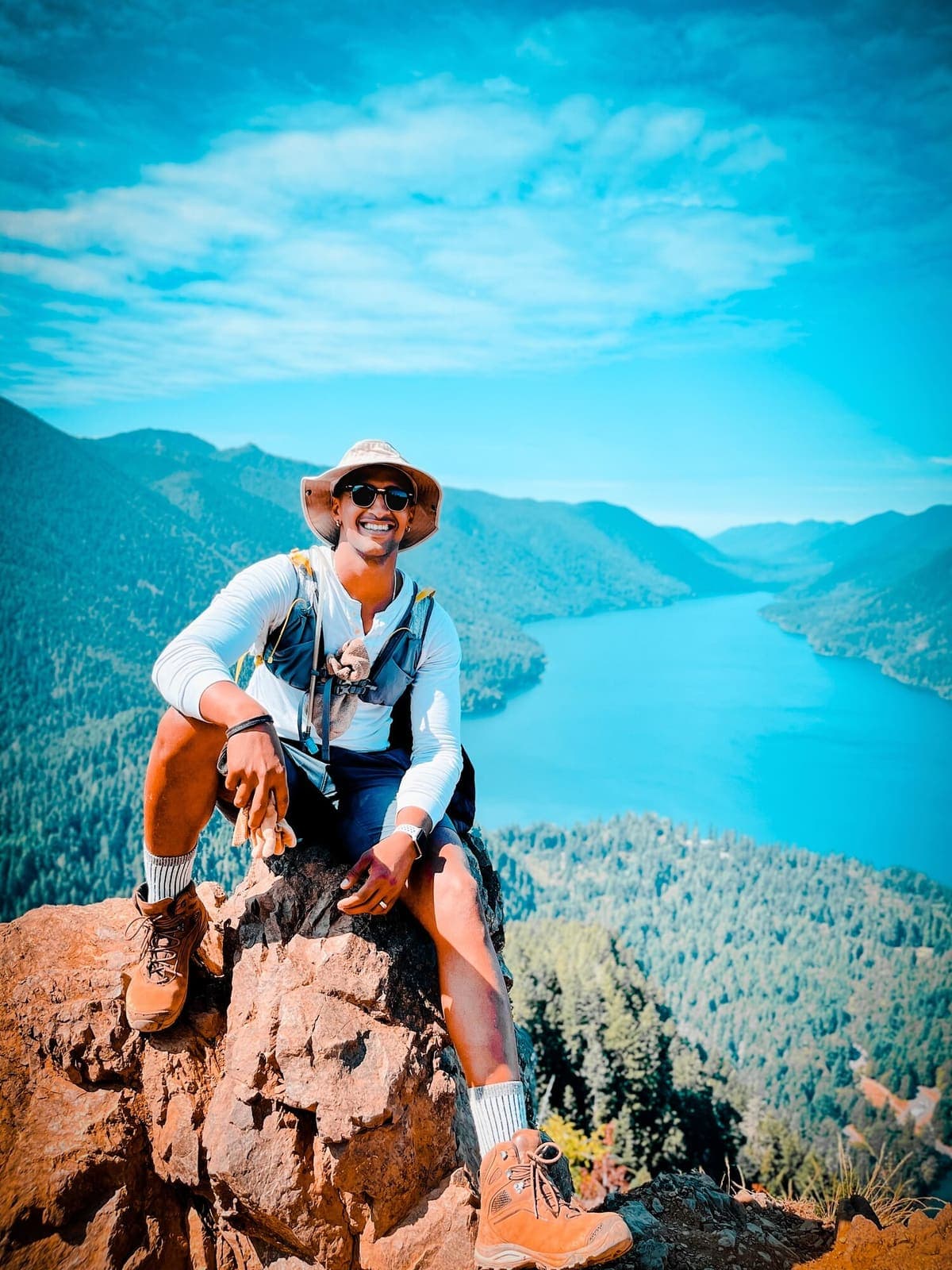 Axe Ahmed resting on a rocky summit above a long blue lake